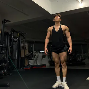 Sportief mannelijk model in een zwart fitness-hemdje in een professionele sportschool