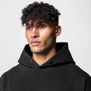 Close-up detail shot of a black hooded sweatshirt featuring a snap-button neckline.