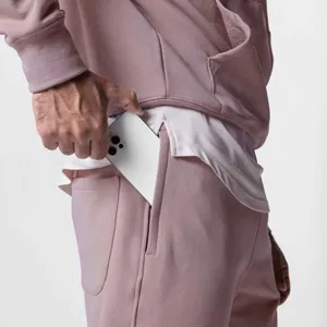 Macro view of side pocket detail on men's oversized dusty rose cotton tracksuit.