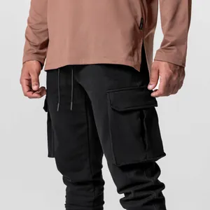 Détail d'un pantalon cargo noir pour homme avec grandes poches et cordon de serrage