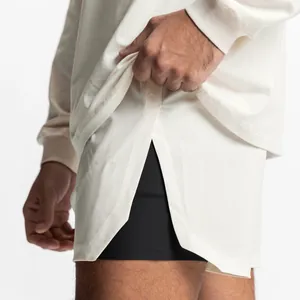 Close-up of men's athletic shorts featuring side slits and black compression liner.
