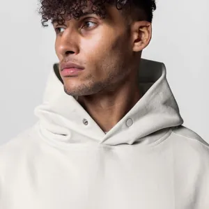 Κοντινή όψη ενός βαριού κρεμ oversized φούτερ με μοναδικά κουμπιά πίεσης στο λαιμό