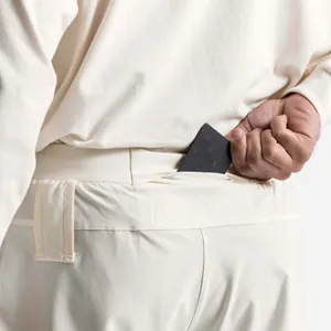 Detailed view of hidden back waistband pocket on cream athletic training shorts
