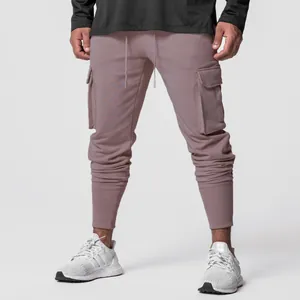 Vue détaillée d'un pantalon cargo slim pour homme en rose poudré avec de grandes poches latérales