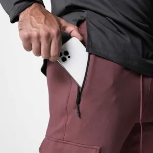 Détail d'un pantalon cargo homme montrant une poche latérale zippée sécurisée pour téléphone