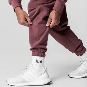 Detail shot of men's maroon cotton sweatpants with elastic cuffed ankles for sports
