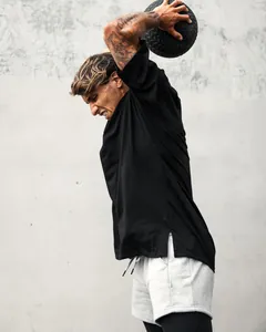 Action shot of men's oversized black sports T-shirt with a side split hem.