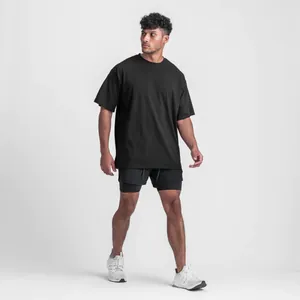 Full-body stride view of a male model wearing a black oversized athletic cotton t-shirt