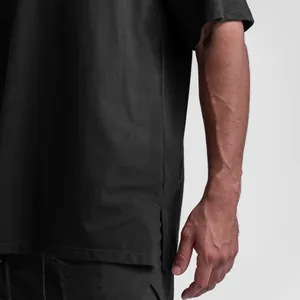 Close-up of black oversized cotton T-shirt featuring a side slit hem for men.