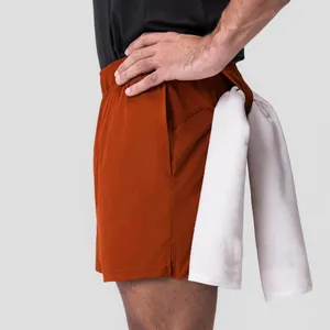 Vista detallada de los pantalones cortos naranjas para hombre con lazo para toalla