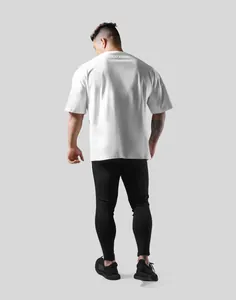 Back view of a man in an oversized white gym T-shirt and black workout leggings
