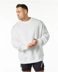 Model wearing oversized white crewneck sweatshirt, showing loose drop-shoulder fit.