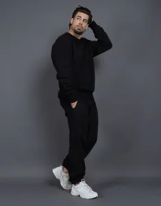 Vista completa del conjunto de sudadera de felpa negra con cuello redondo y pantalón holgado
