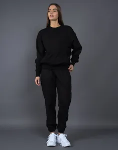 Vista completa del conjunto de chándal negro con sudadera de cuello redondo y pantalón ancho