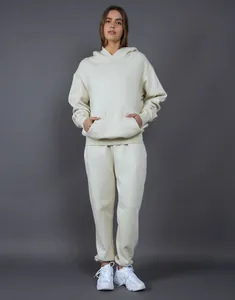 Front view detail of a woman wearing a cream oversized fleece hoodie and jogger set
