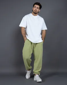 Modello maschile con joggers in pile verde chiaro e t-shirt bianca in studio