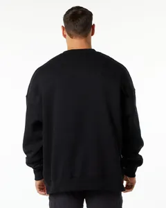 Rear view detail of an oversized black crewneck sweatshirt with dropped shoulders.