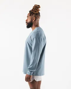Seitenansicht eines blauen, locker sitzenden Langarm-Sportshirts für Herren am Model