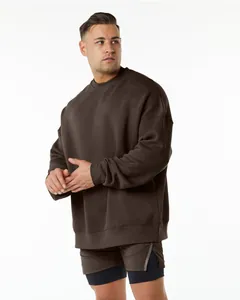 Male model wearing an oversized dark brown fleece crewneck sweatshirt with drop shoulders