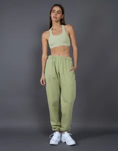 Donna indossa set pantaloni joggers oversize in pile 400G verde salvia e reggiseno.