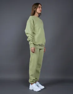 Vista lateral de un conjunto premium de sudadera y pantalón de chándal verde salvia oversize