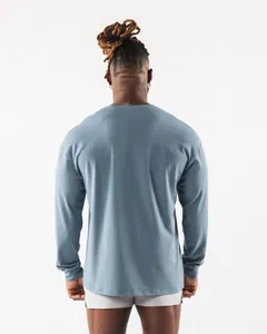Detaillierte Rückansicht eines Mannes in einem lockeren blauen Langarm-Sport-T-Shirt.