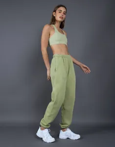 Dettaglio ravvicinato dei pantaloni jogging spessi in pile verde salvia vestibilità relax