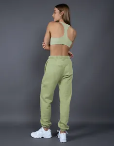 Vista posteriore di una donna con joggers felpati verde salvia e reggiseno sportivo