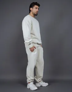 Perfil lateral de un modelo con un conjunto de chándal de forro polar crema de estilo minimalista