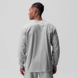 Vista posteriore di un modello che indossa una t-shirt sportiva grigia a maniche lunghe con girocollo