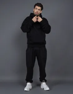 Model wearing a black 400G fleece tracksuit with hoodie and matching joggers.