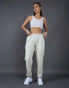 Modella indossa pantaloni della tuta color crema in pile con vestibilità morbida