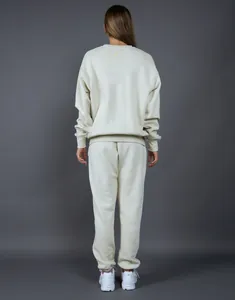 Vista trasera de un conjunto de sudadera de cuello redondo y pantalón de chándal crema