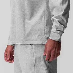 Dettaglio di una maglietta sportiva a maniche lunghe grigia da uomo e abbigliamento relax