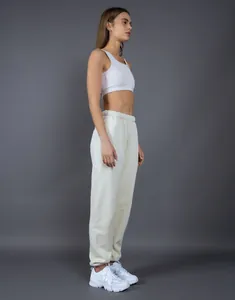 Vista laterale dettagliata dei pantaloni sportivi color panna foderati in pile 400G su modella