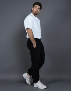 Vista a figura intera di un uomo che indossa pantaloni della tuta neri oversize in pile