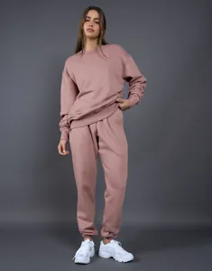 Foto de cuerpo completo de una modelo con un conjunto de sudadera y pantalón de felpa rosa