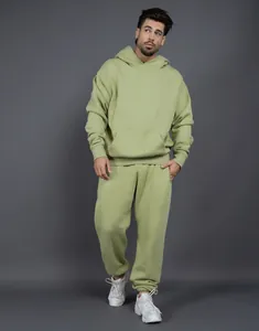 Male model showcasing a light green oversized fleece hoodie and sweatpants two-piece set