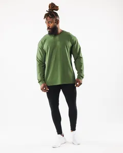 Ganzkörperaufnahme eines Mannes in einem lockeren grünen Sport-Langarmshirt