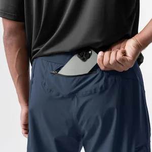 Detailansicht der Reißverschlusstasche an der dunkelblauen Herren-Sporthose mit Smartphone