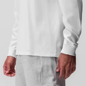Dettaglio che mostra il polsino a coste e il tessuto di una t-shirt bianca da uomo a maniche lunghe
