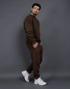 Hombre con un conjunto de chándal de forro polar marrón oversize con sudadera y jogger