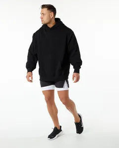 Close-up of men's heavyweight black oversized hoodie in a sporty studio setting.