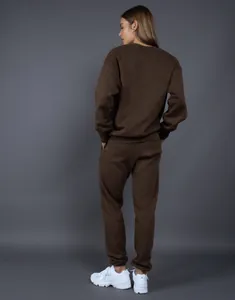 Vista trasera de un conjunto de sudadera de cuello redondo y pantalón de chándal marrón