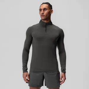 Professional men's athletic compression long sleeve top featuring a half-zip collar in charcoal