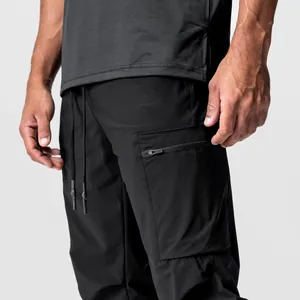 Nahaufnahme einer schwarzen Outdoor-Cargohose mit Reißverschlusstasche und Kordelzug am Bund