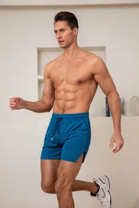 Sportieve man in blauwe ademende sneldrogende sportshort voor hardlopen en fitnessen.