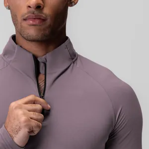 Macro view of a men's mauve half-zip compression athletic shirt showing fabric texture details