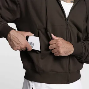 Detail eines braunen Herren-Kapuzenpullovers mit großer, funktionaler Vordertasche