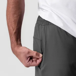 Detalle de primer plano del bolsillo lateral con cremallera en pantalones cortos grises